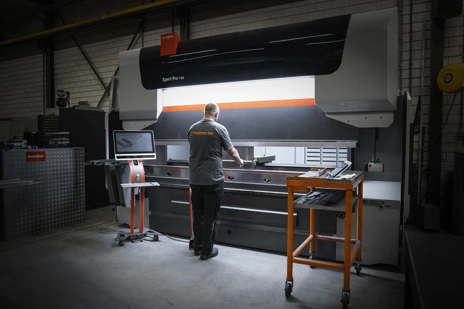 Een medewerker van Python aan het kanten op een CNC-kantbank